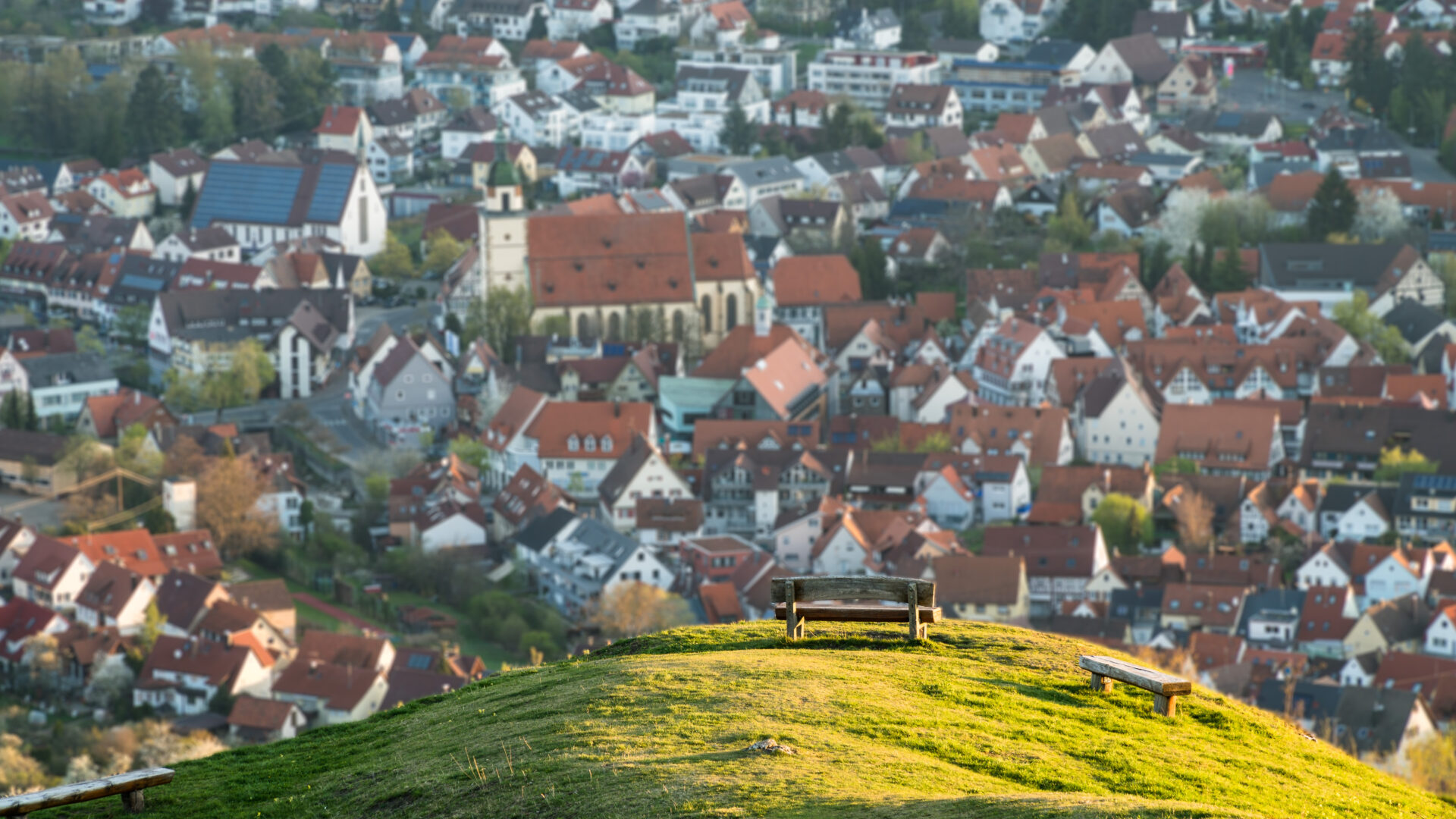 Eine Bank auf einem Hügel mit Blick auf die Stadt Weilheim an der Teck