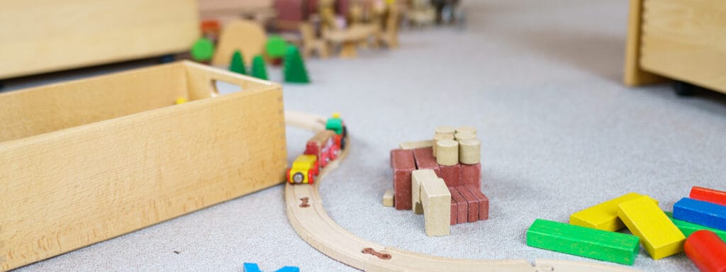 Ein Kinderspielzimmer mit buntem Holzspielzeug und einer Kiste